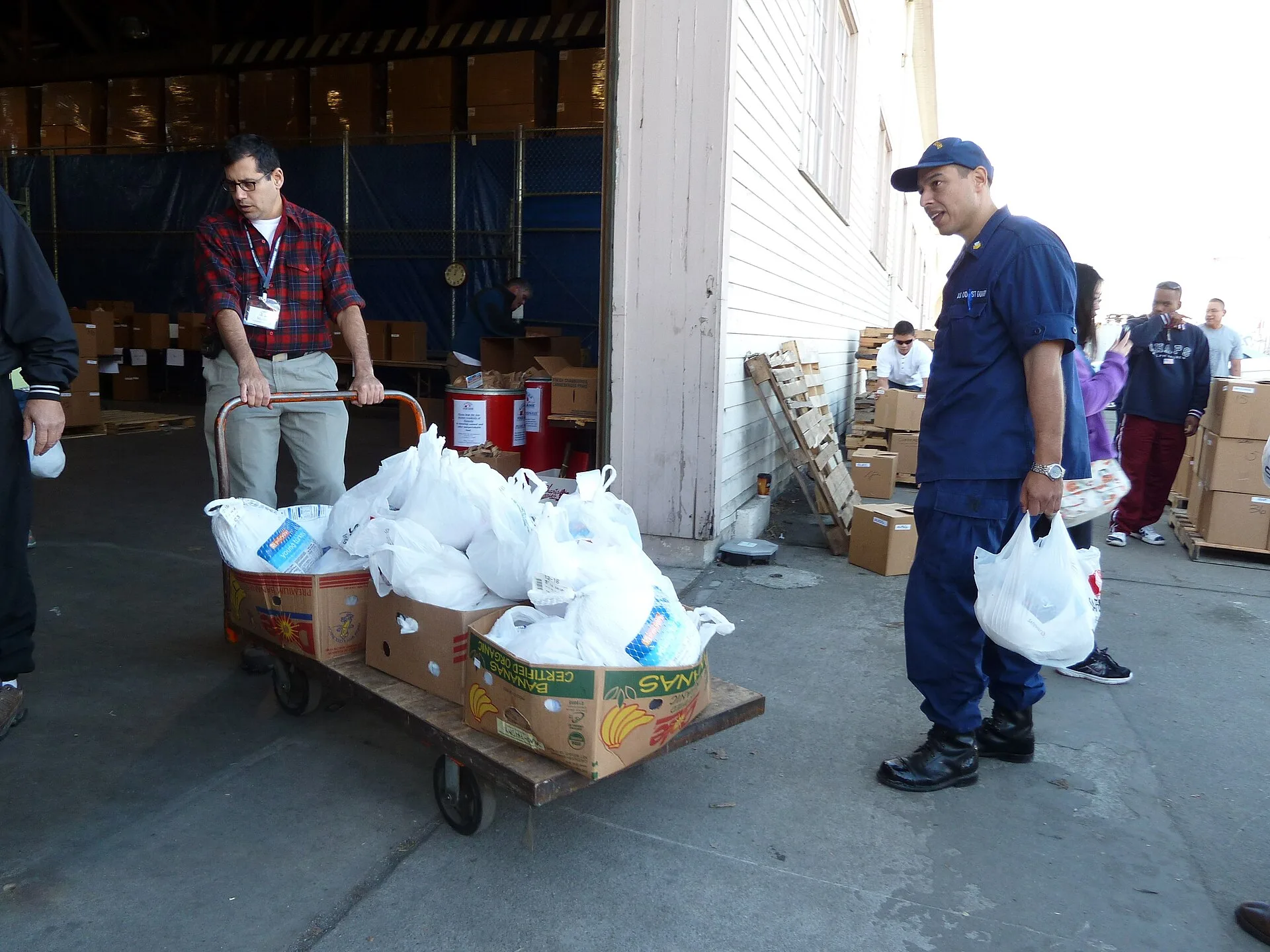 Volunteers handing out grocery bags at a Thanksgiving food drive